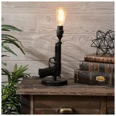 Base Dimensions: 6" x 5.38" Full Height: 12" Cord Length: 61.5" Bulb Type: A 60W Power Source: Corded Electric Material: Resin Color: Black Quantity: 1 Shoot straight for an action hero theme with our Black Pistol Decorative Table Lamp! This cool lamp offers a realistic upright pistol shape with a brushed black finish and distressed gold details. Add a light bulb and a lampshade to shed some light in your bedroom, man cave, or shop! Masculine Room, Cool Lamp, Upcycled Lighting, Electric Material, Bedroom Man Cave, Action Hero, Large Lamps, Room Stuff, Cool Lamps