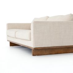 a white couch sitting on top of a wooden frame