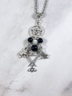 This beautiful chain necklace is the perfect way to express your affinity for Lucifer. Charms: Ram Sigil Crow 3 onyx beads and one selenite bead also make up the pendant. Your choice of top charm: Pentacle or Chandelier Available in a variety of lengths. Secured with a lobster clasp. Chain is stainless steel. Charms are zinc alloy. All materials are lead and nickel free. Comes in a jewelry box so it's ready to be given as a gift. Have a idea for a custom order? I'd love to hear it! Just click th Spiritual Black Necklaces With Charms, Spiritual Silver Charm Necklaces With Gemstone Beads, Slavic Goddess, Greek Mythology Jewelry, Mythology Jewelry, Sparkly Accessories, Grunge Jewelry, Garnet Bracelet, Onyx Bead