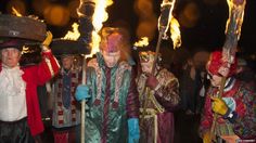 several people dressed in costumes and holding fire sticks