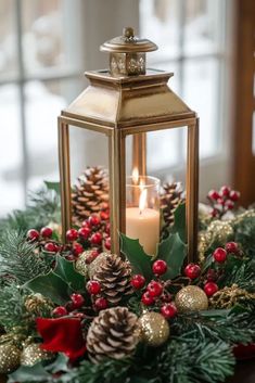 a christmas centerpiece with pine cones, holly berries and a lit candle on top