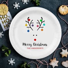 a paper plate with reindeer faces on it and christmas decorations around the edges, along with cookies