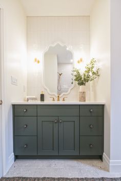 a bathroom with green cabinets and a large mirror on the wall over the sink area