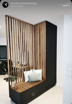 a wooden bench sitting next to a white wall in a room with wood slats on it