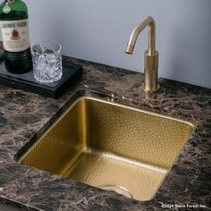 a kitchen sink with a bottle of alcohol on the counter