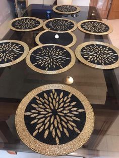 several black and gold plates sitting on top of a glass table