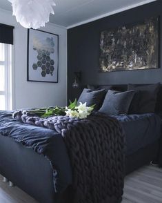 a bedroom with black and white decor, blue bedding and pictures on the wall