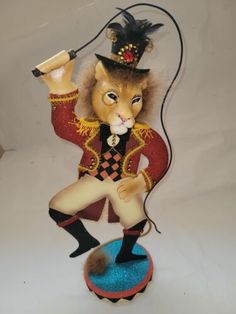 a figurine of a lion wearing a top hat and holding a microphone in its hand