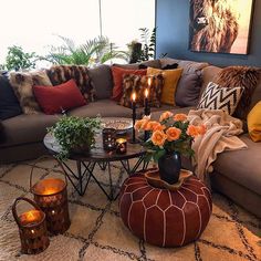 a living room filled with lots of furniture and candles on top of it's coffee table