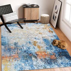 a dog laying on top of a blue rug in a living room next to a chair