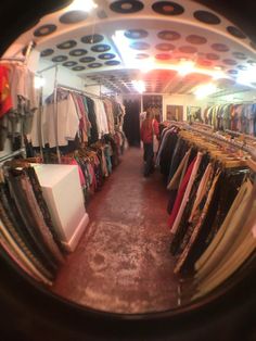 an image of a store that is full of clothes and ties on display in the mirror