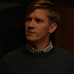 a man in a black sweater looking at the camera