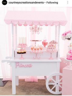 a pink and white dessert cart with cupcakes on it