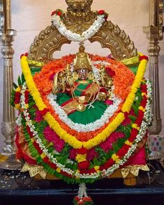 the statue is decorated with flowers and garlands