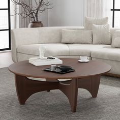 a living room with a couch, coffee table and vase on the carpeted floor