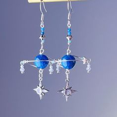 Blue Apatite Planet and Stars Silver Drop Earrings Add a celestial touch to your outfit with our original Blue Apatite Planet and Stars Silver Drop Earrings! The natural apatite crystal used in these unique earrings not only adds a pop of blue, but also has healing powers to clear confusion. Give the gift of inspiration and healing with these one-of-a-kind earrings. The planet is made from natural apatite stone. The green planet and stars earrings are handmade locally in the UK. As a gift shop, Blue Star Charm Dangle Earrings, Blue Dangle Earrings With Star Charm, Blue Star-shaped Celestial Jewelry, Blue Celestial Dangle Earrings, Celestial Blue Star-shaped Jewelry, Blue Star Charm Drop Earrings, Blue Celestial Pierced Earrings, Celestial Blue Pierced Earrings, Blue Drop Earrings With Star Charm