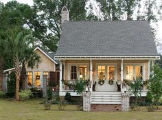 a small house with porches and plants on the front