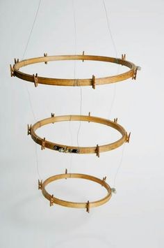 three circular wooden objects hanging from strings on a white background with no people around them