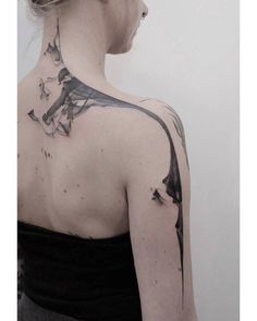 the back of a woman's neck with black ink and watercolors on it