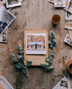 a wooden table topped with pictures and plants