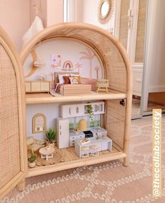 a doll house with furniture and accessories on display in a room that is decorated in wicker