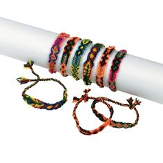 several bracelets are sitting on top of a white tube and next to each other