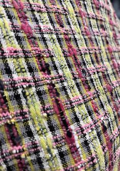 a close up view of the back of a tweed jacket with pink, green and yellow stripes