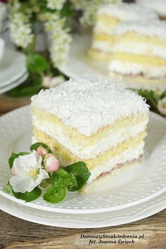 a piece of cake on a white plate with flowers and greenery next to it