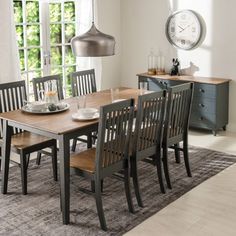 a dining room table and chairs with a clock on the wall in the back ground