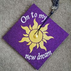 a purple and yellow graduation cap that says on to my new dream