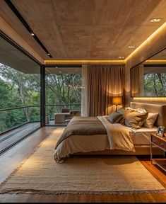 a large bed sitting in the middle of a bedroom next to a tall glass wall