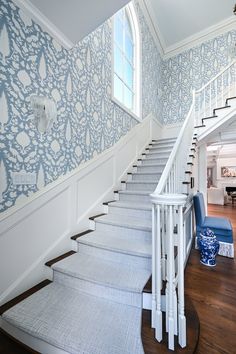 a staircase with blue and white wallpaper on the walls