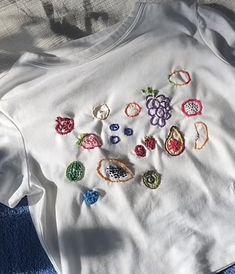 a white t - shirt with embroidered designs on it