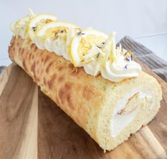 a piece of bread with lemons and whipped cream on it sitting on a cutting board