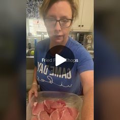 a woman holding a plastic container filled with raw meat