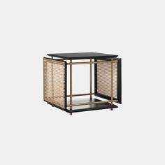 a black and gold side table with an open shelf on the top, in front of a white background