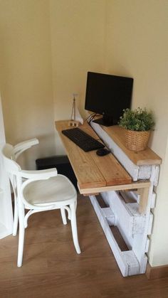 a desk with a computer on top of it and a chair in front of it