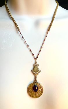 I made this out of a lovely old Art Nouveau locket that does not open. It has a garnet on it and there is an Edwardian element as well. It has a gold and ruby rosary chain. Gold Oval Garnet Necklaces, Oval Garnet Gold Necklace, Victorian Gemstone Oval Pendant Necklace, Victorian Gemstone Necklace With Oval Pendant, Victorian Oval Pendant Necklace With Gemstone, Victorian Oval Pendant Gemstone Necklace, Antique Gemstone Oval Pendant Necklace, Antique Oval Pendant Gemstone Necklace, Elegant Handmade Antique Gold Locket Necklace