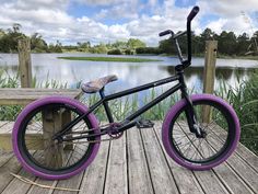 a black and purple bike parked on a wooden dock