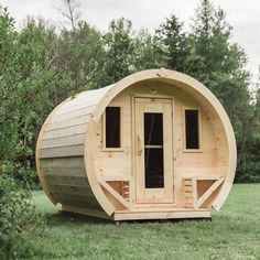 a wooden barrel like structure sitting in the grass