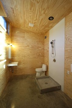 a bathroom with wooden walls and concrete flooring