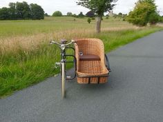 a bike with a basket attached to the front is parked on the side of a road