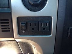 an electrical outlet in the center console of a car