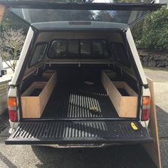 the back end of a vehicle with its cargo compartment open and two wooden drawers in the trunk