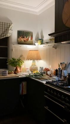 a kitchen with an oven, sink and table lamp in the corner next to it