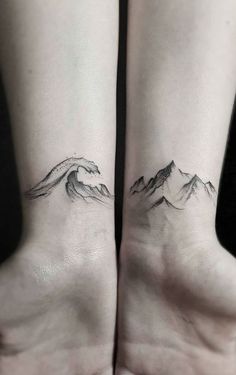 two people with matching tattoos on their feet, one is holding the other's hand