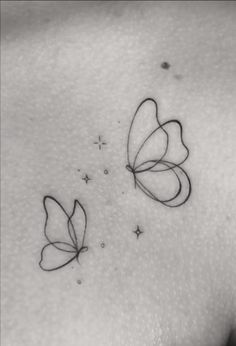 two butterflies on the back of a woman's shoulder