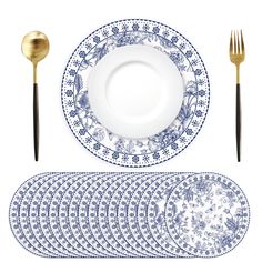 blue and white plates with gold cutlery, forks and spoons are arranged on a white surface