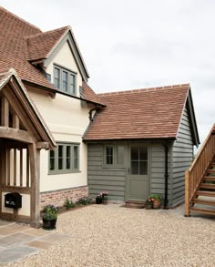 the front of a house with gravel driveway and steps leading up to it's entrance