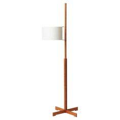 a wooden floor lamp with a white shade